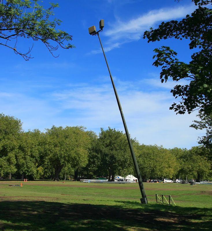 A leaning lamp post in a park.