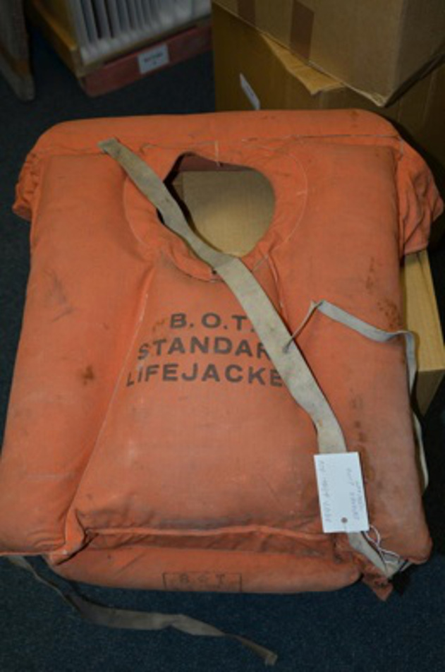 An orange lifejacket stamped with the words B.O.T. standard lifejacket. An orange lifejacket stamped with the words B.O.T. standard lifejacket.
