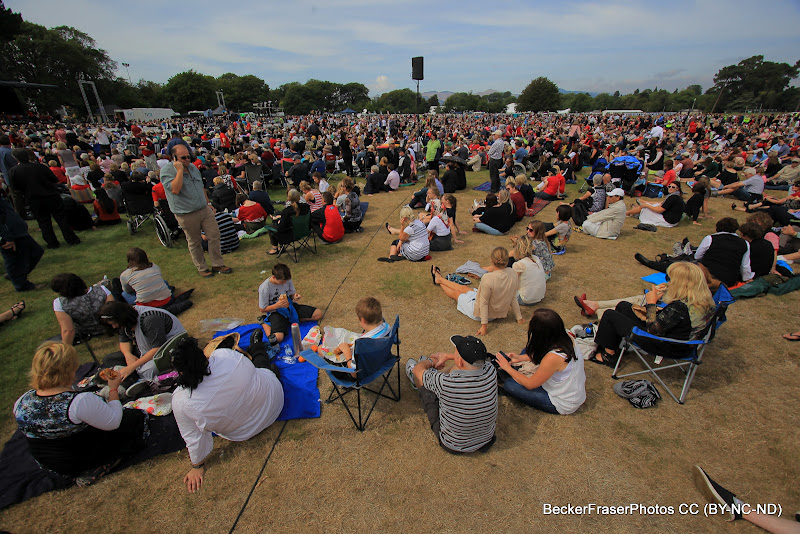 A crowd of people sitting in a park.