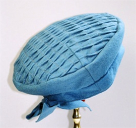 Blue round hat with with rows of pintucks on top and a bow at the back.