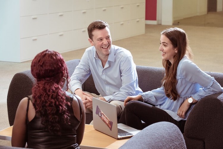 Three MDLZ employees smiling having a discussion