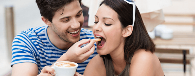 Two people smiling and snacking