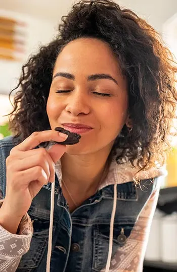 Woman enjoying Oreo cookie.