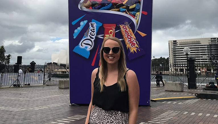 Majella in front a Cadbury sign in the harbour