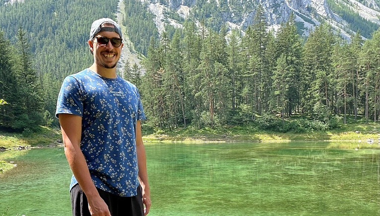 man standing in front of a lake