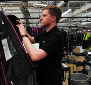 A young man sorts through a rack of clothing