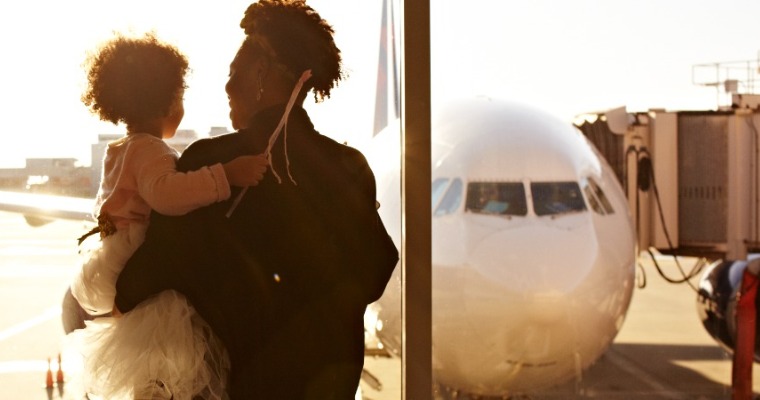A woman and a child looking at a plane out of a window