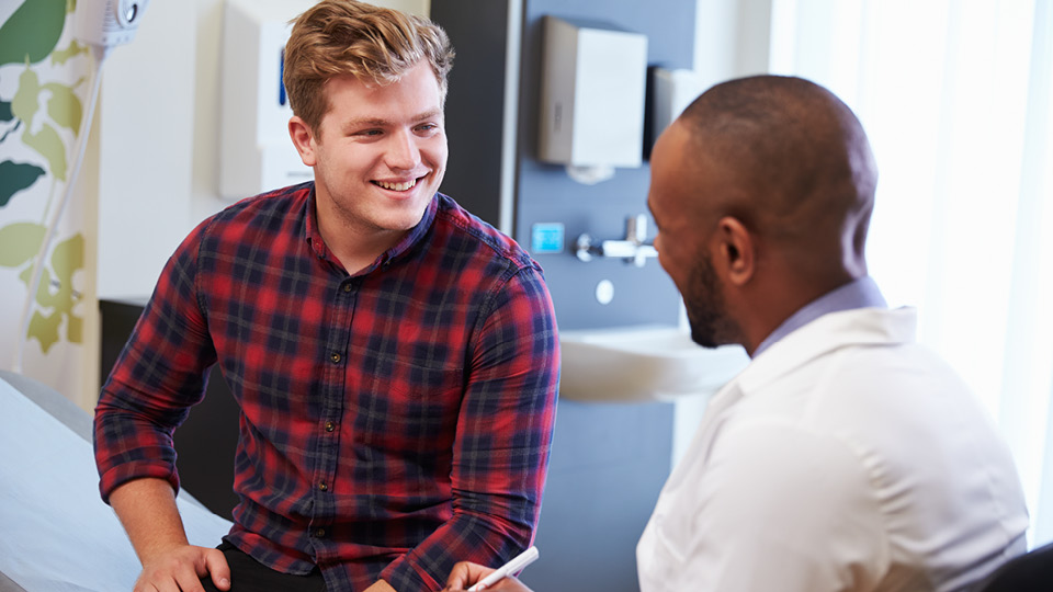 A young man chats to his doctor.