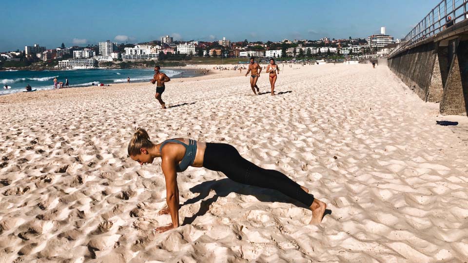 A person doing a plank on a beach.