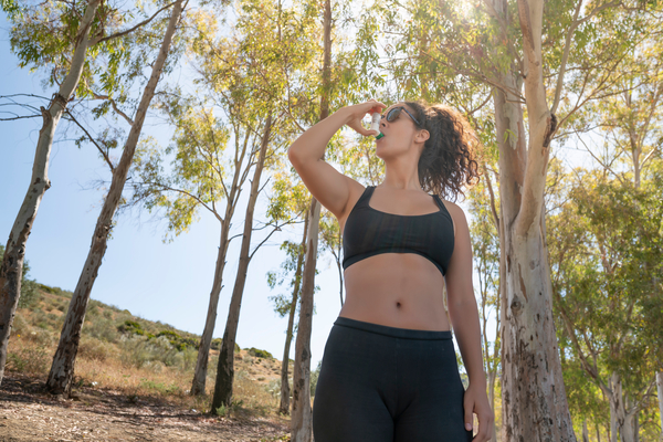 A woman uses her asthma puffer while exercising in the outdoors