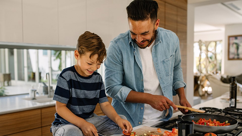 A father cooking a healthy dinner with his son.