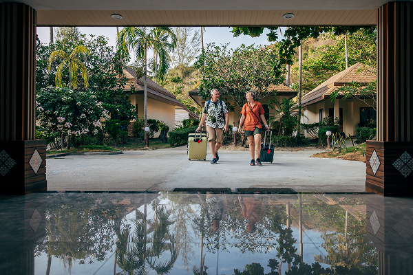 A couple wheeling their suitcases into a hotel