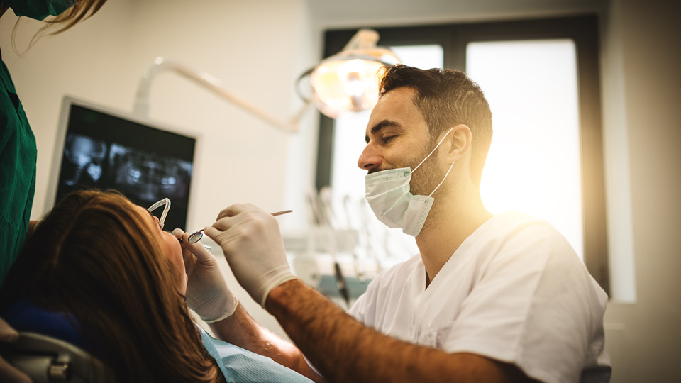 Dentist performing an oral examination on a patient.