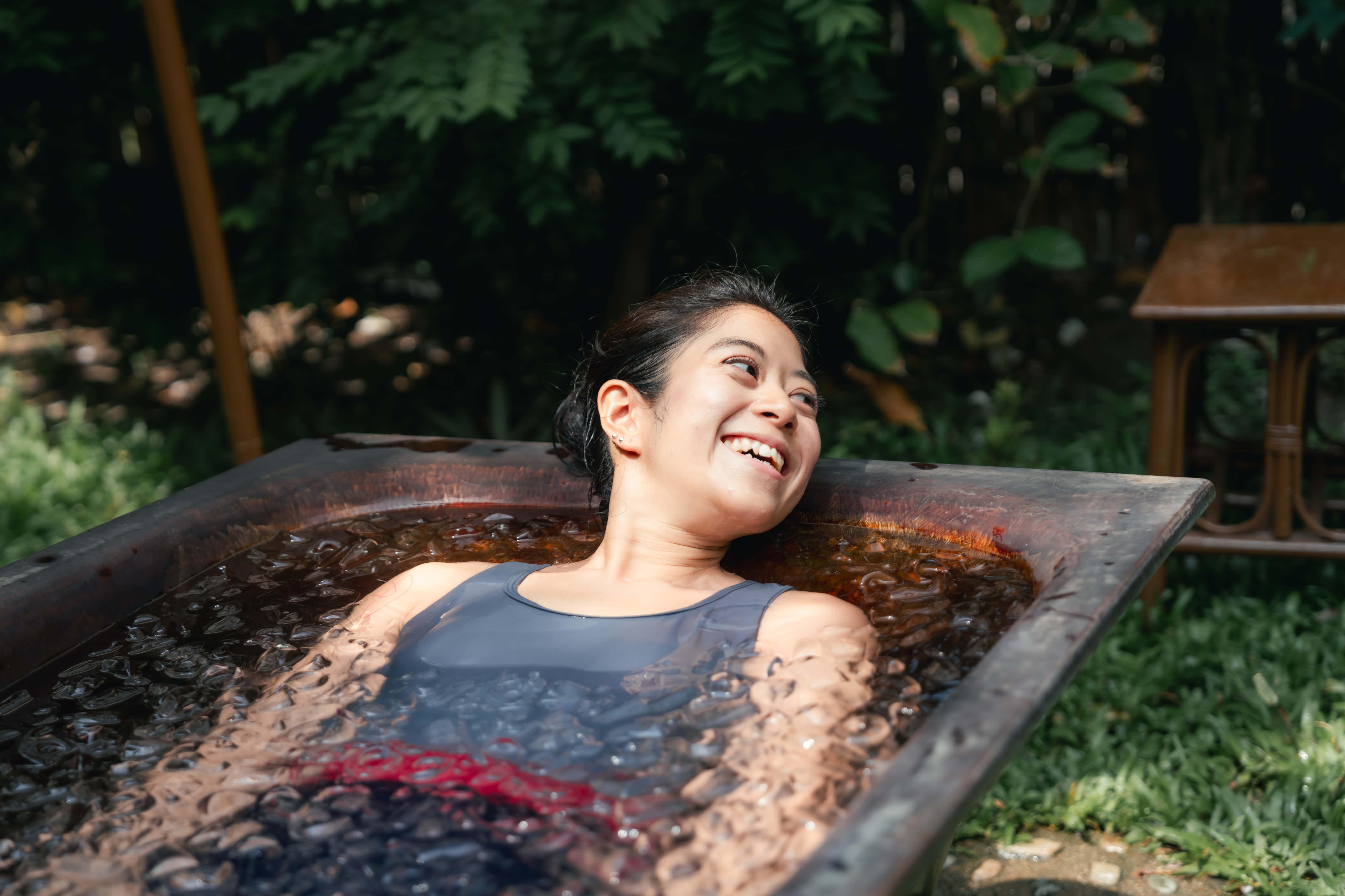 Woman in ice bath outside smiling.