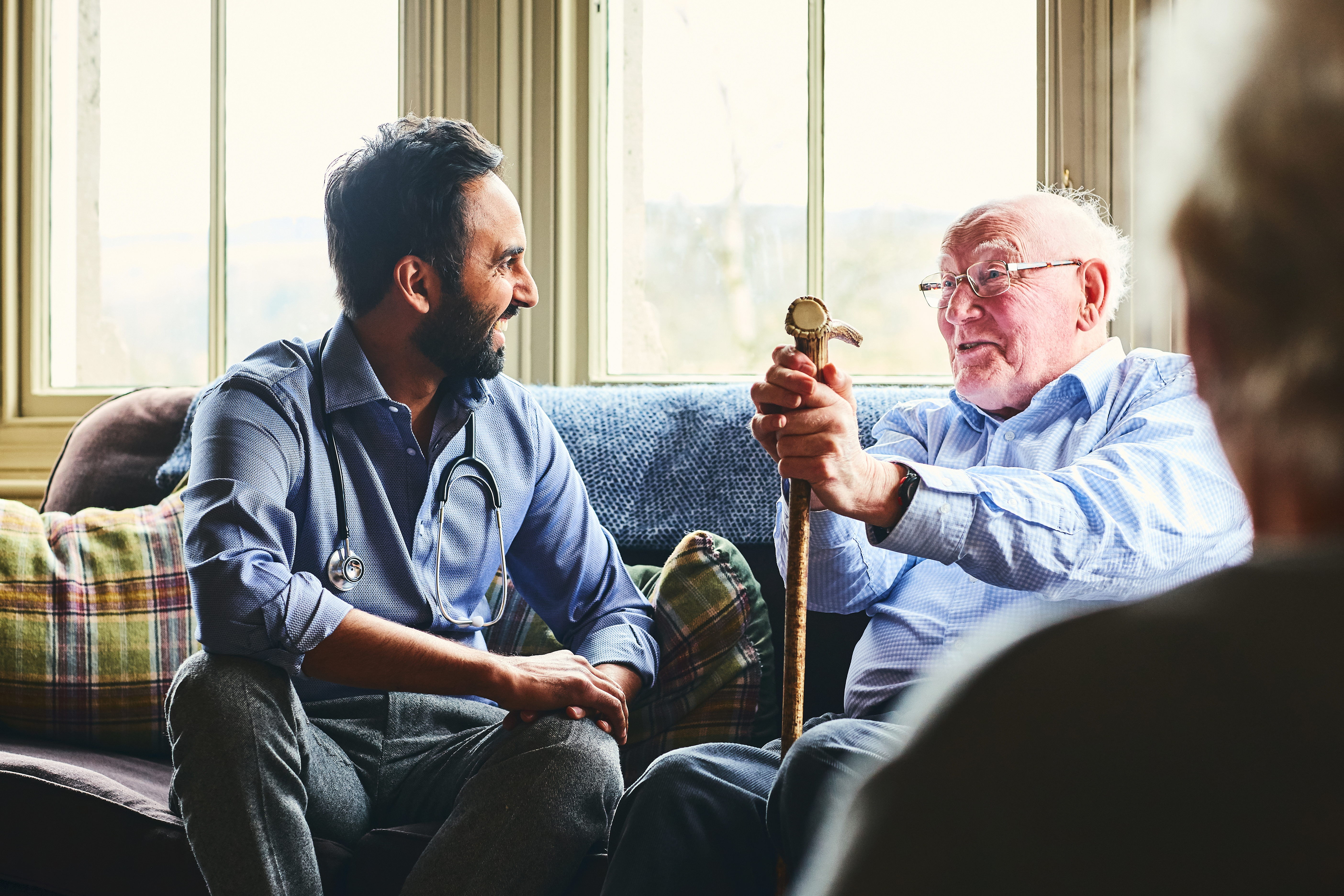 Smiling doctor visiting senior man at home
