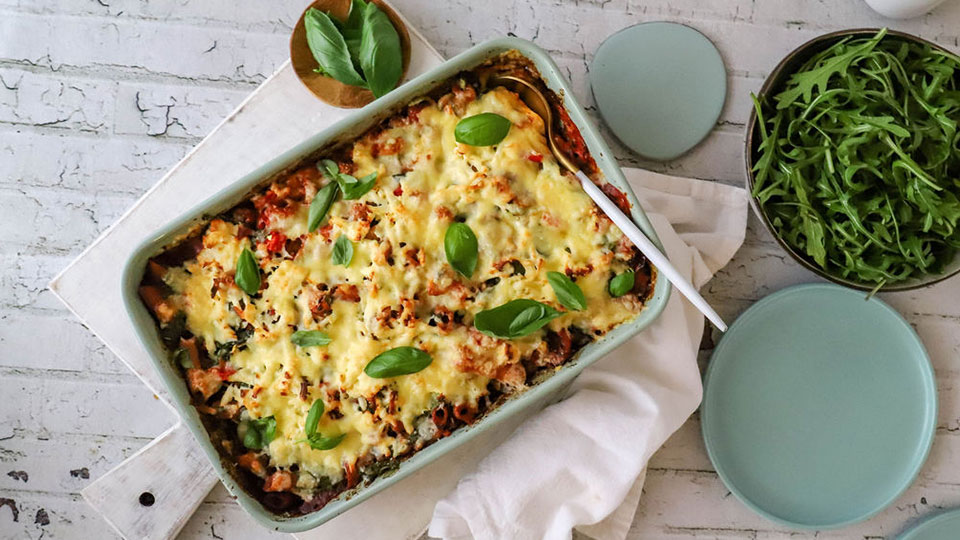 Pasta bake in a baking tray with salad on the side.