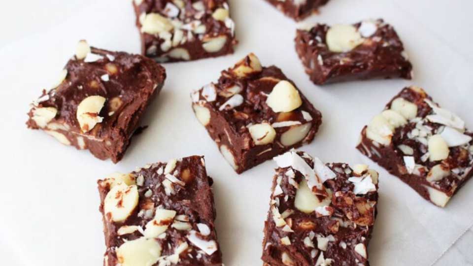 6 slices of chocolate and macadamia brownies on a white kitchen bench.