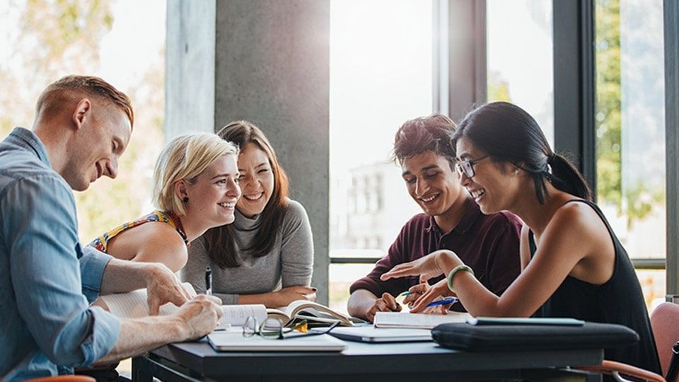 A group of students sitting around a table studying.