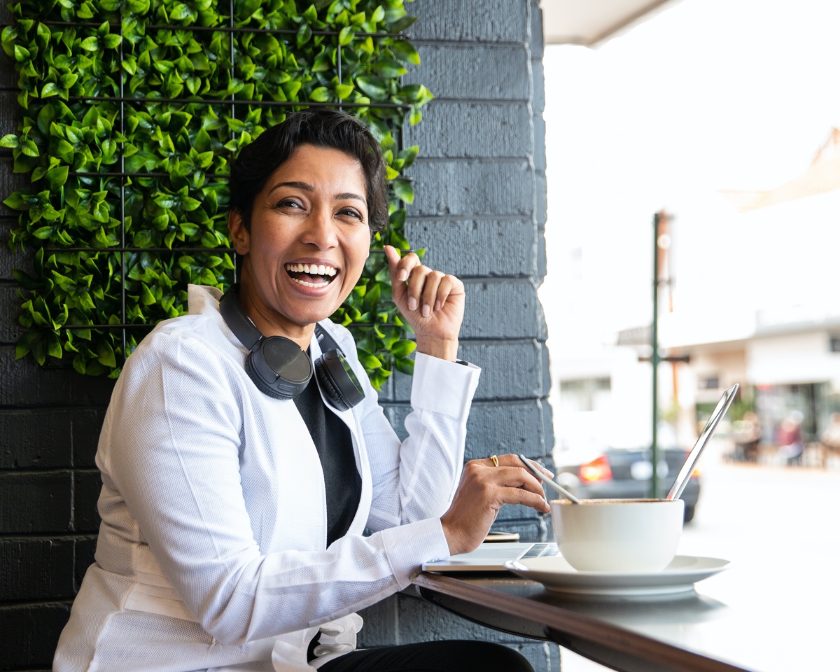 A woman laughing in a cafe.