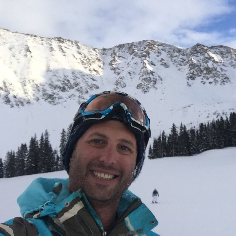 A picture of a smiling man taking a selfie in the snow