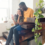 Couple sitting on steps looking at a phone