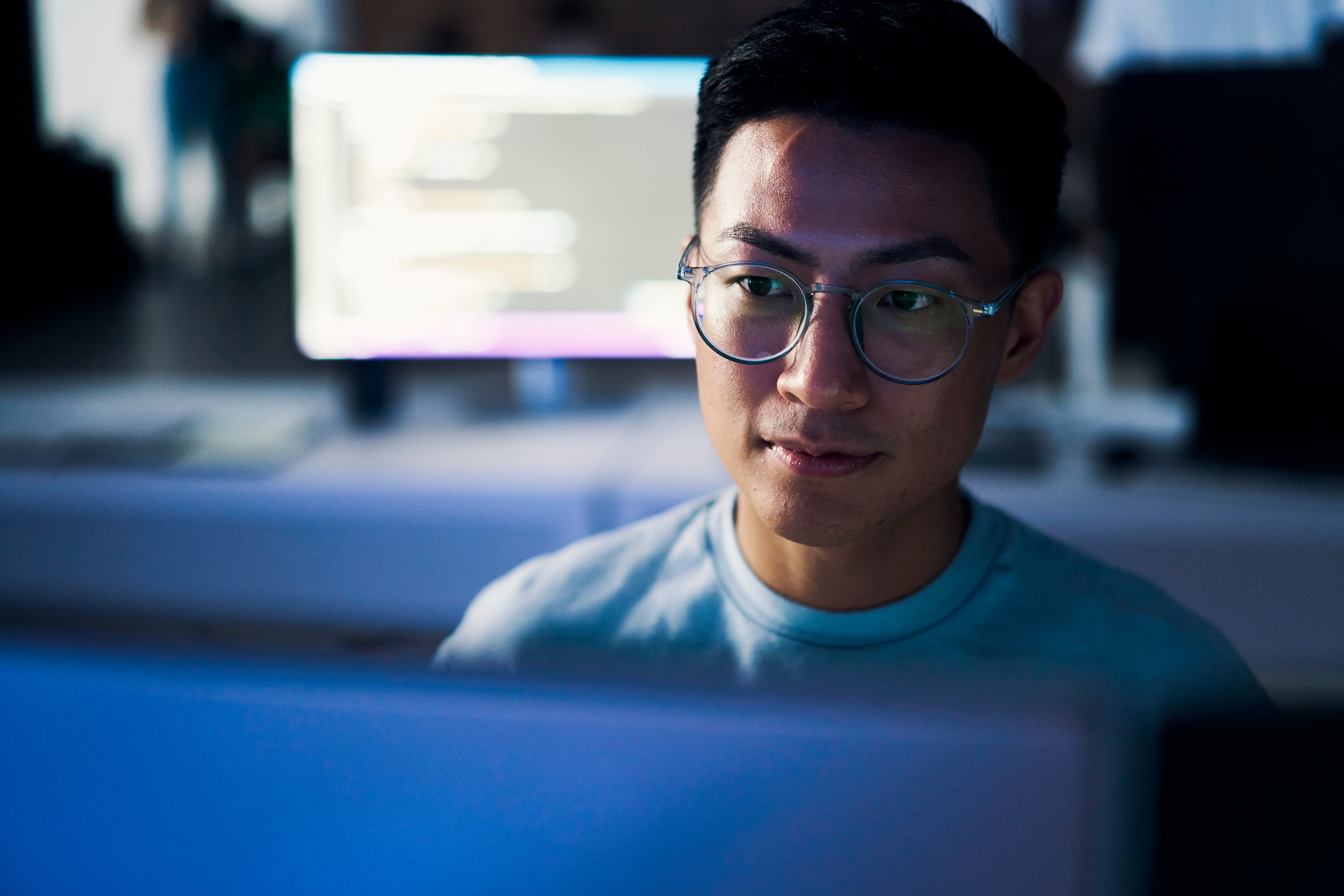 Person wearing glasses, working at a computer.