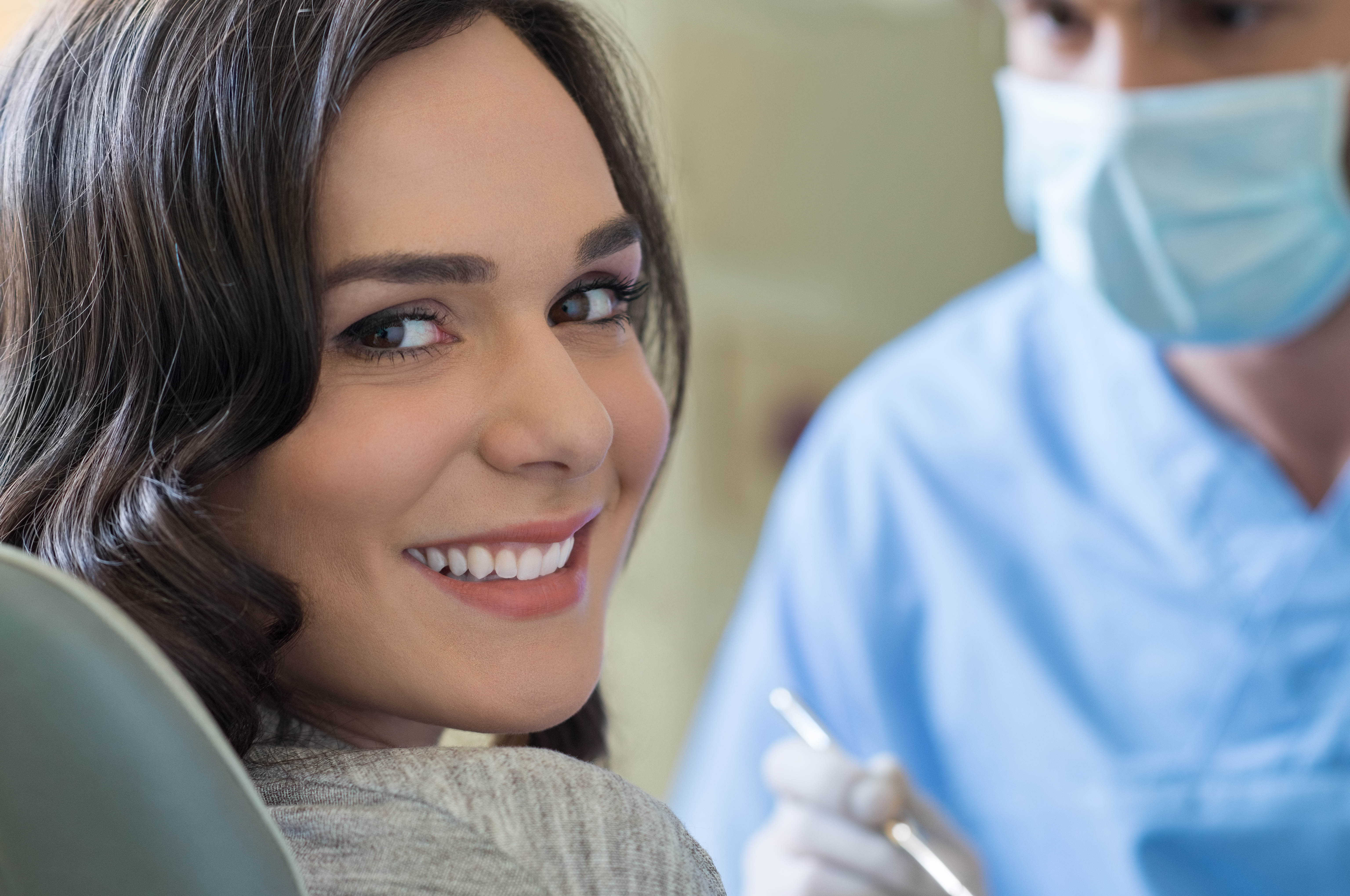 Patient smiles at screen next to dentist