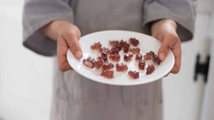 Close up of a person holding a plate of gummy bears.