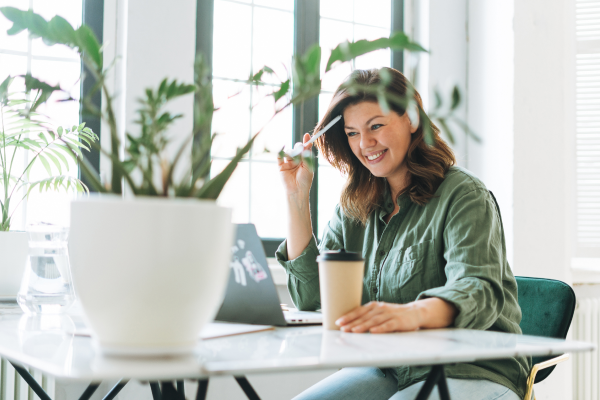Woman wearing green shirt working at her desk