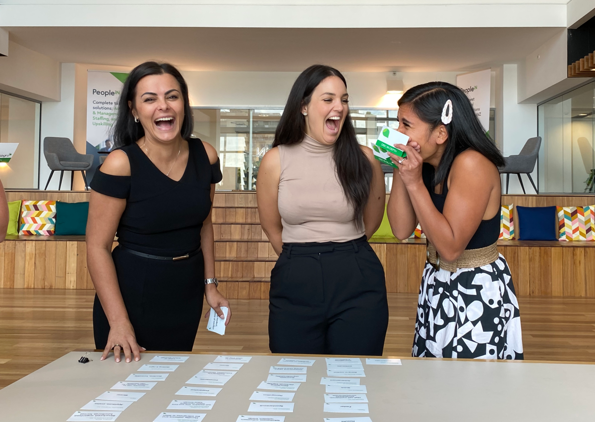 Three happy female PeopleIN employees in the office