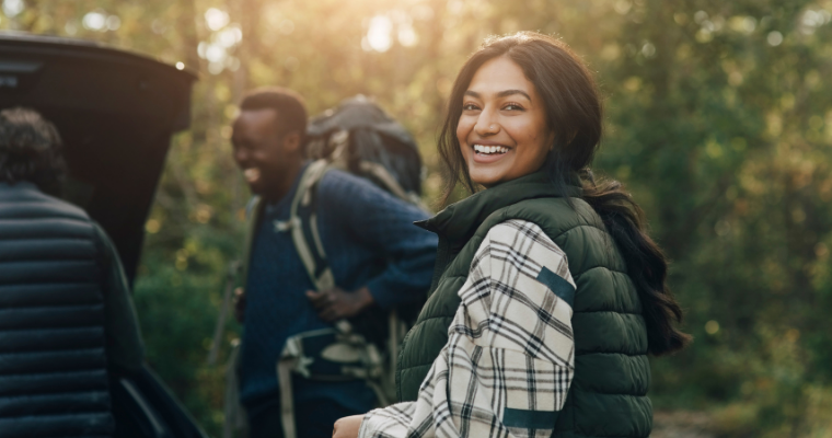 A smiling woman hiking with friends