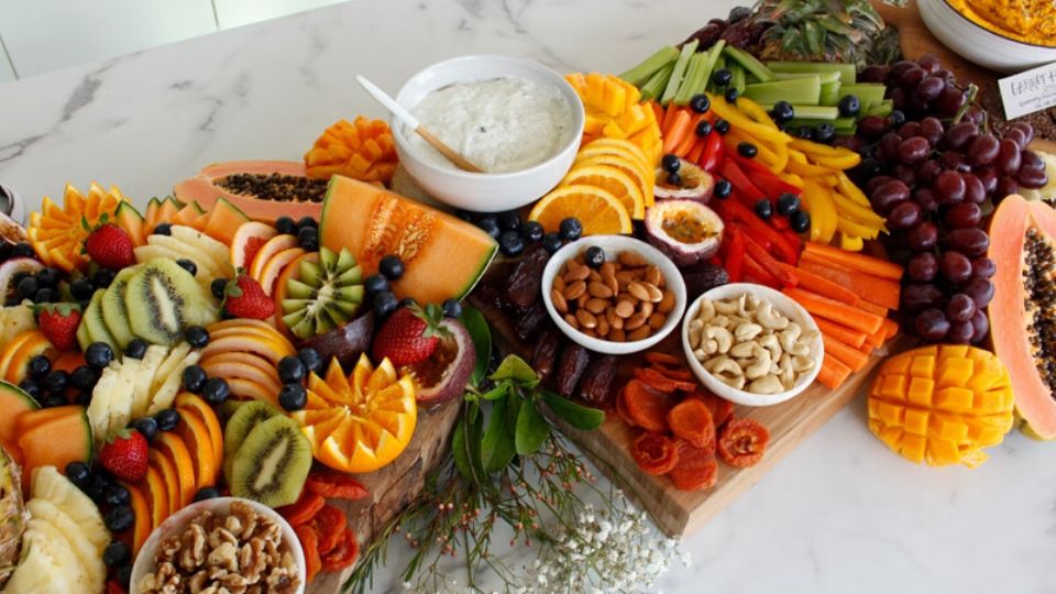 Overhead angle of a grazing table including fruit, dips, dried fruit, vegetables and nuts.