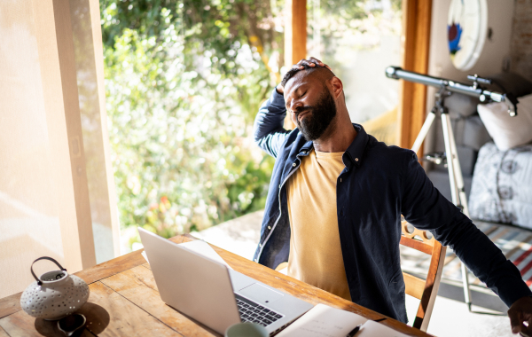 A man sitting at his desk doing stretches