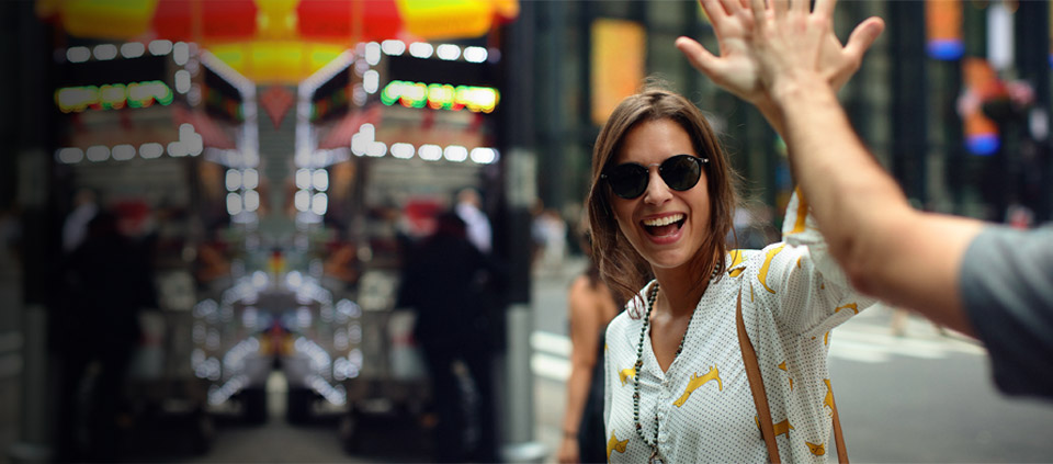 A smiling woman high-fiving an unpictured man
