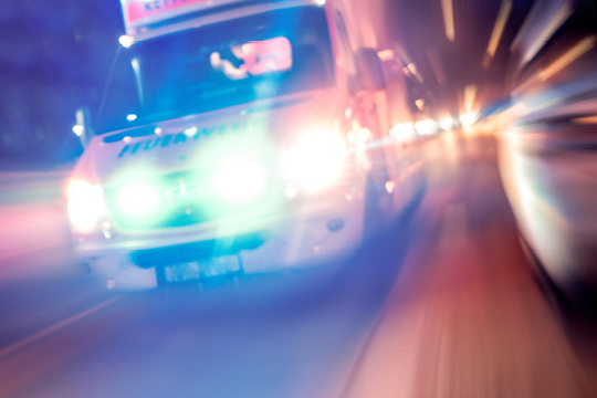 Blurred image of ambulance on the road indicating the ambulance is travelling at high speed.