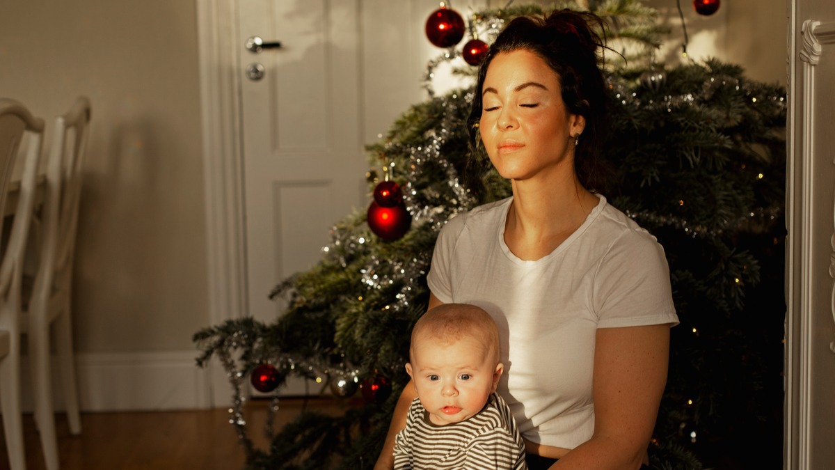 Mother and child sitting in front of a Christmas tree.