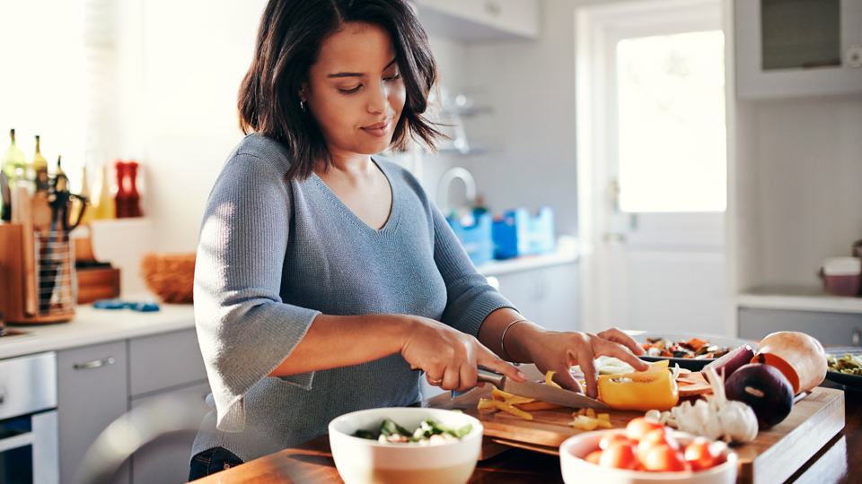 A woman preparing vegetables for a meal.