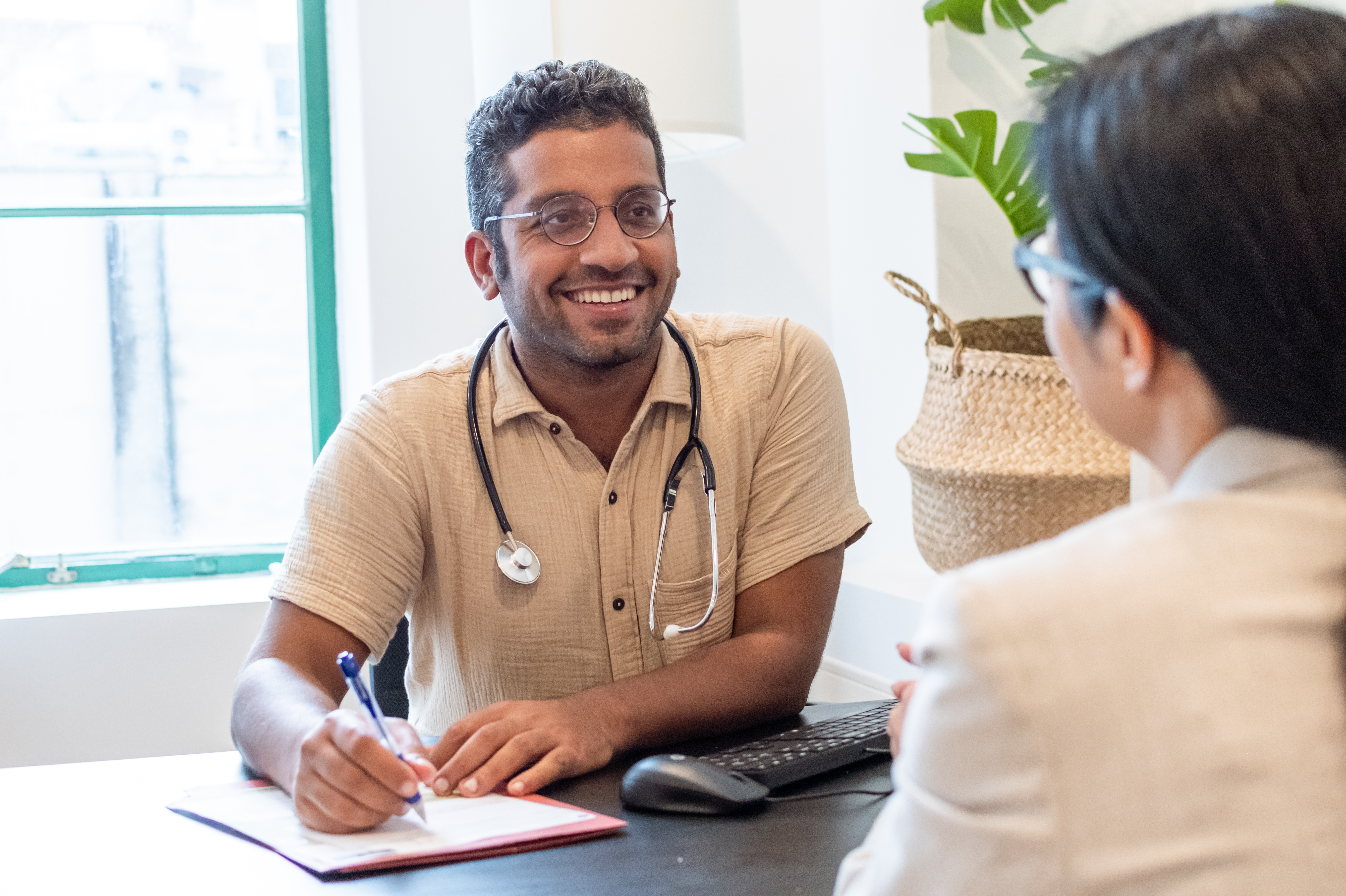 Doctor with stethoscope around neck in an appointment with patient