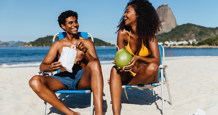 Two people sitting on the beach in beach chairs