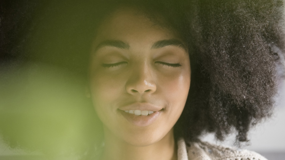 Close up photo of someone looking relaxed with their eyes closed.