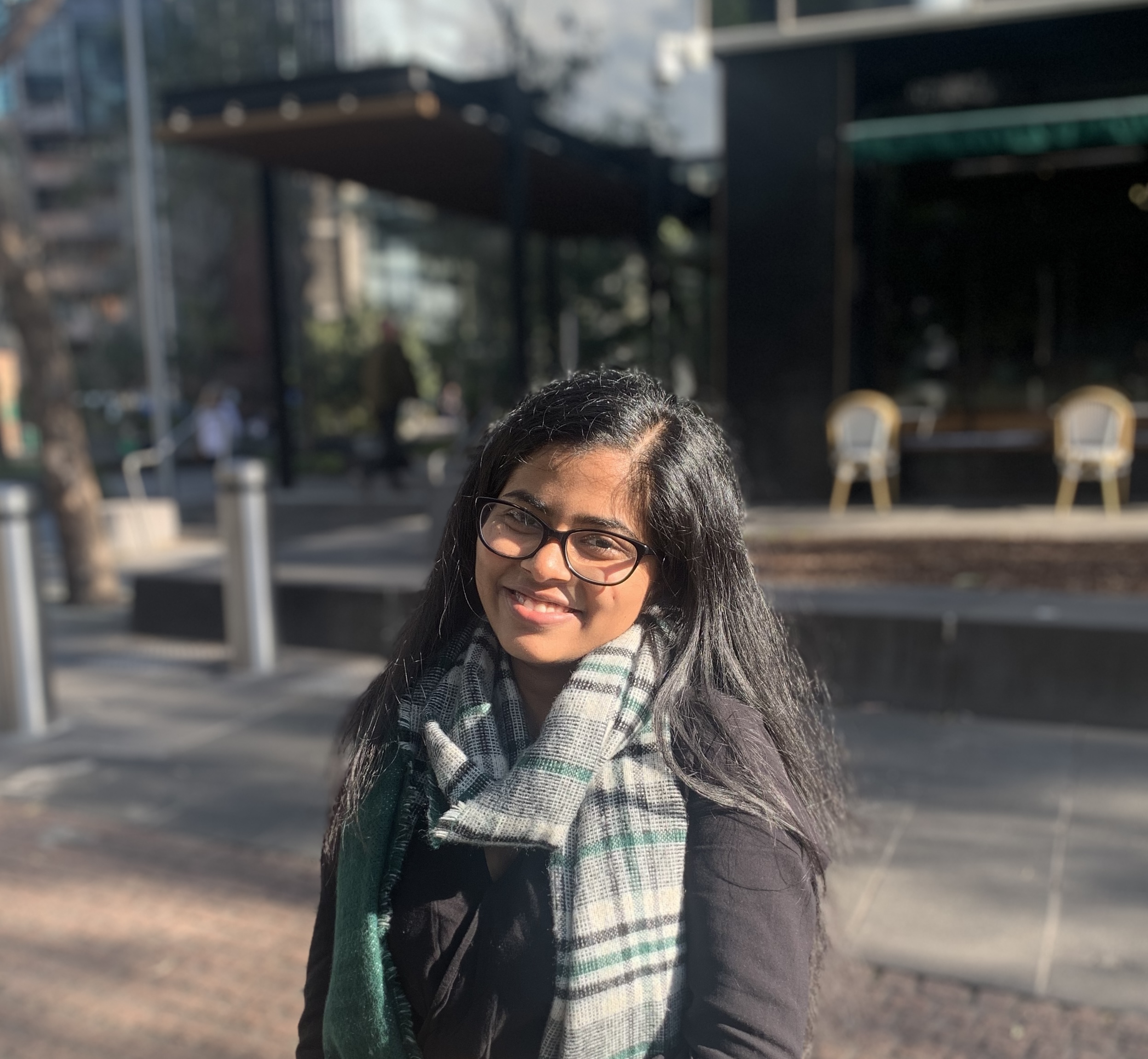 Close up photo of a person wearing a scarf in an urban area.