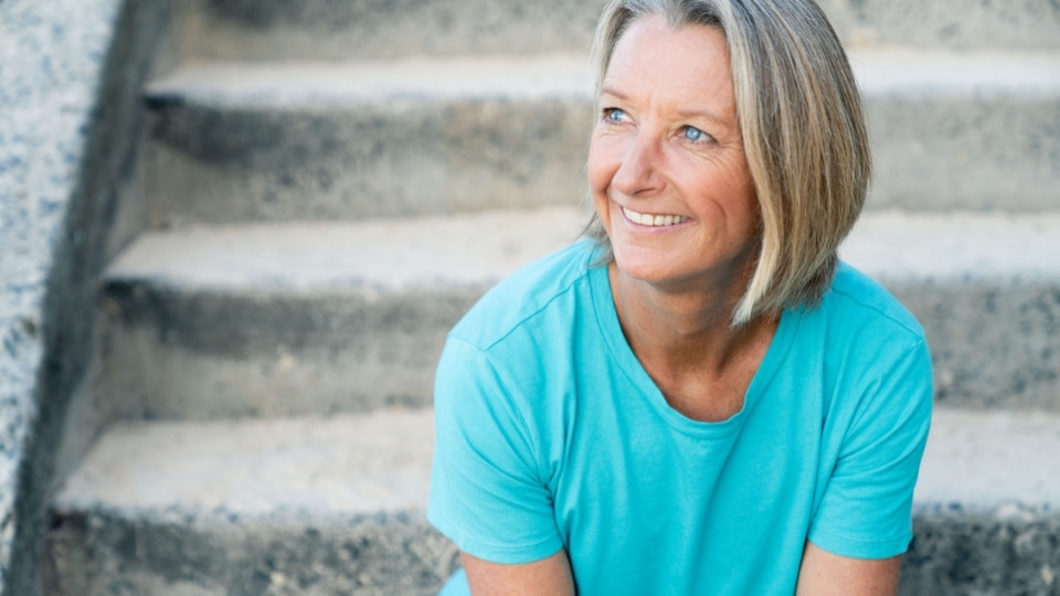 Layne Beachley sitting at the bottom of the stairs at the beach.