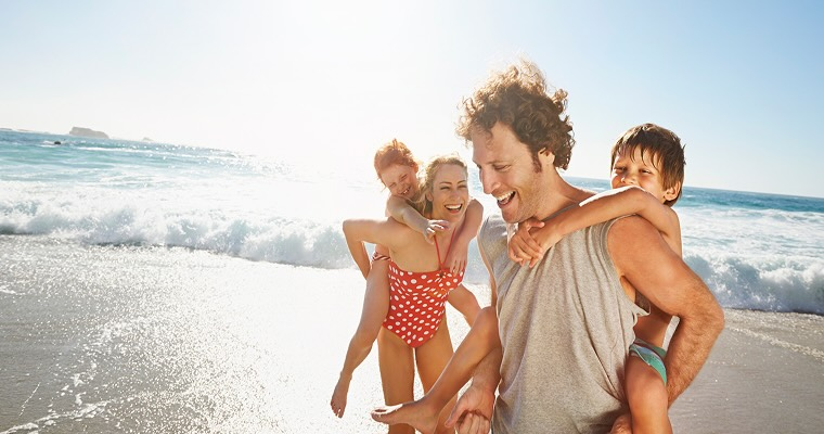 A family smiling and laughing on a beach