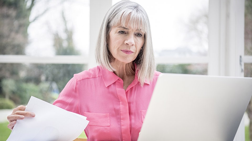 A senior woman examines documents