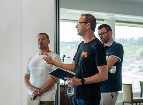 A male nib employee talking while holding a notebook