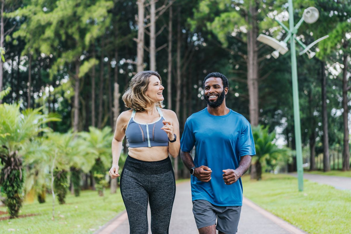 Two people walking through a public park, smiling.