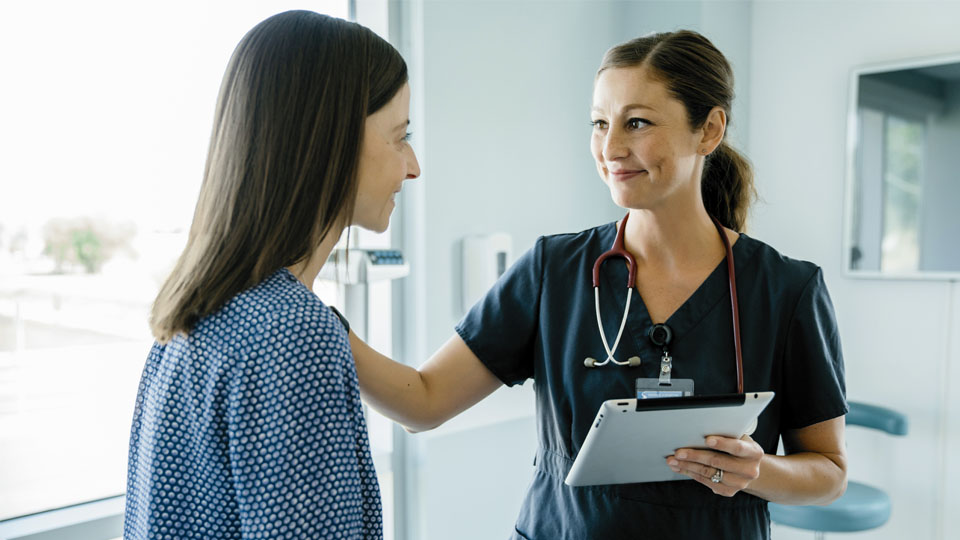 A woman chats to her female doctor.