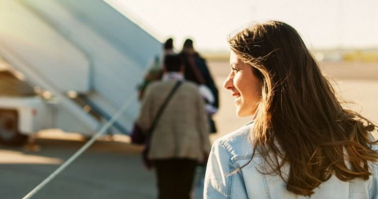 A woman appoaching a plane to board