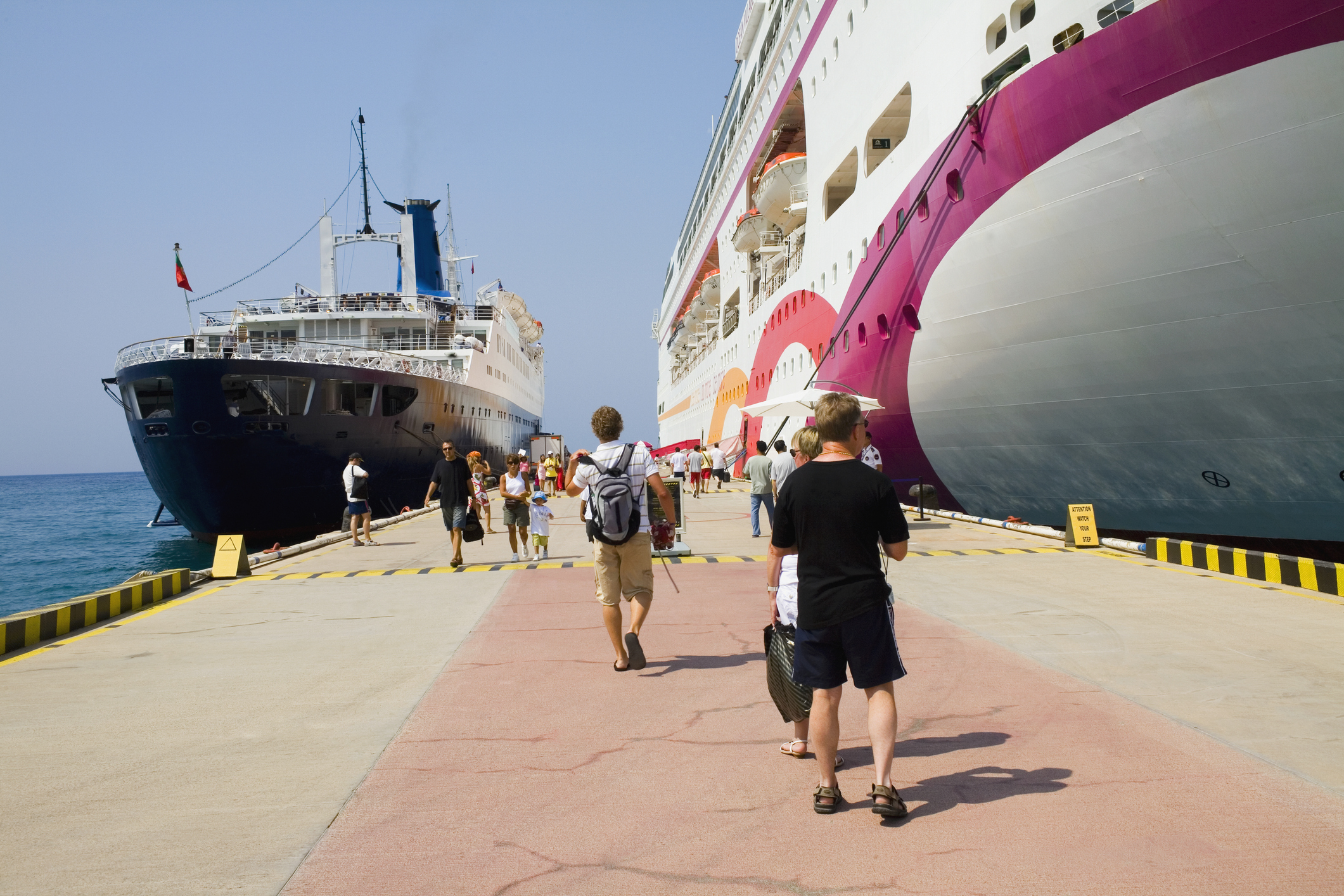 Travellers walking between two cruise ships moored at a harbour in Ephesus, Turkey