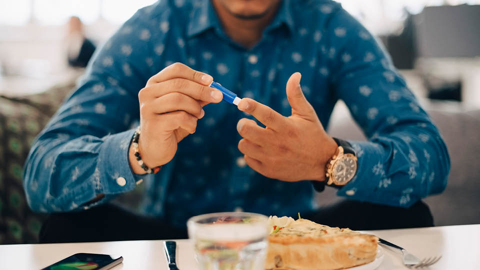 A close up of a man pricking his finger